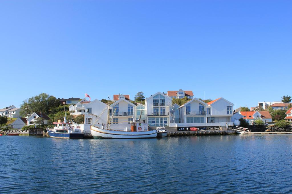 un grupo de casas y un barco en el agua en Hummeren Hotel en Tananger