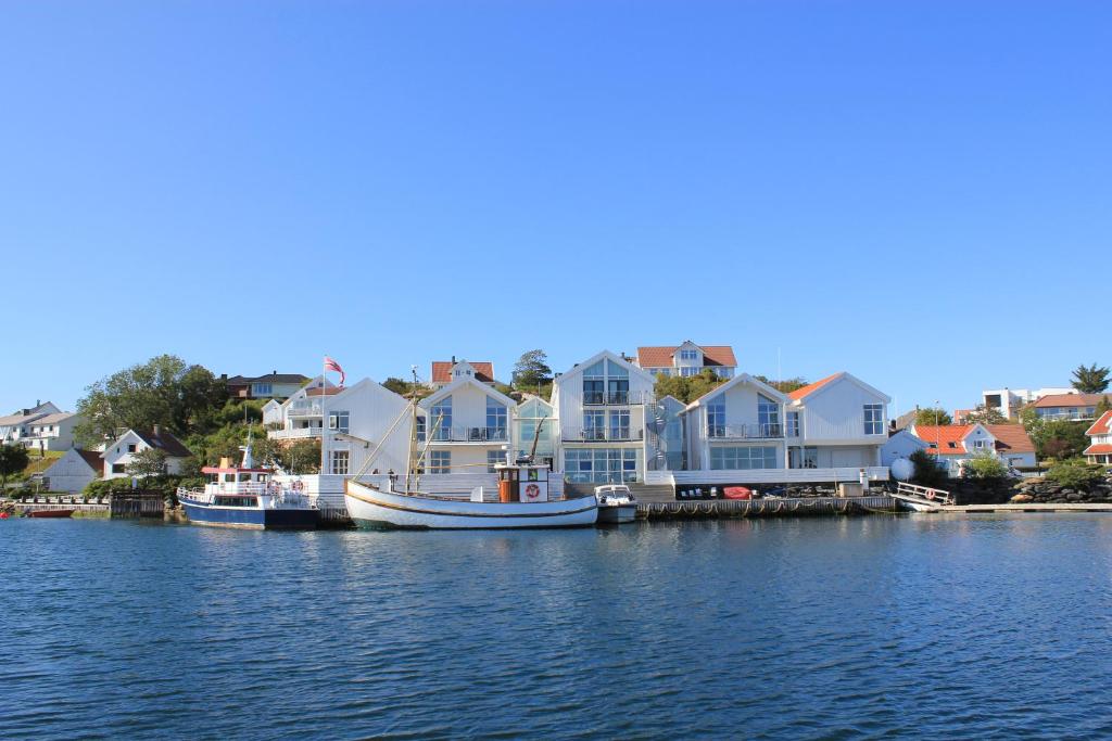 a group of houses and a boat in the water at Hummeren Hotel in Tananger