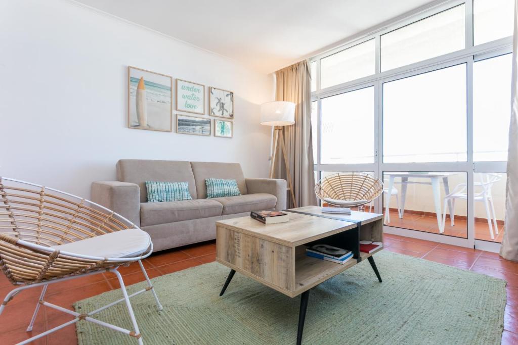 uma sala de estar com um sofá e uma mesa em Water Green House - Praia da Rocha em Portimão