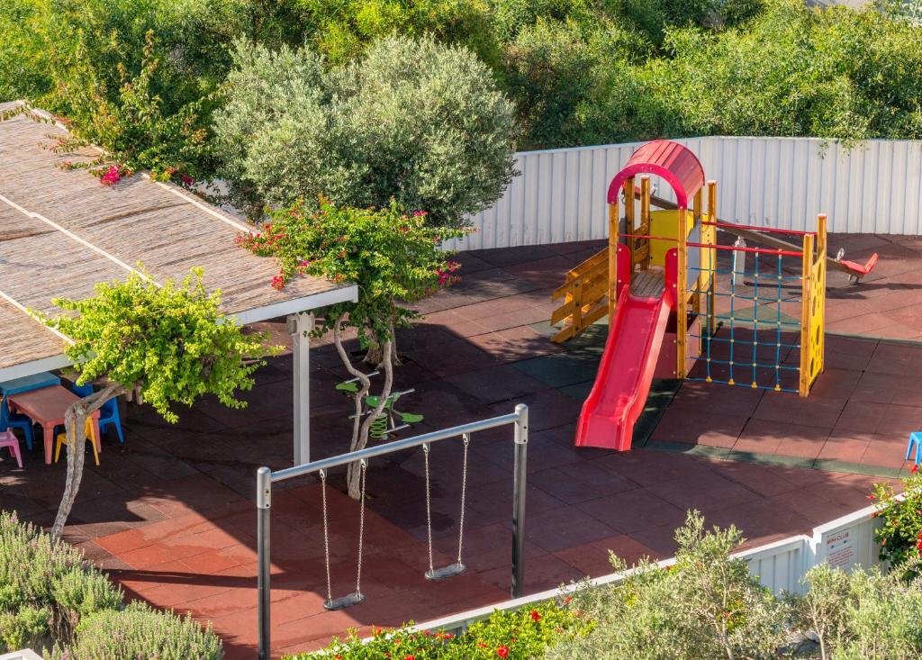 a playground with a slide in a garden at Nissi Beach Resort in Ayia Napa