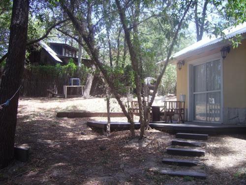 una casa con un porche y un banco junto a un árbol en casa mandarina en Mar de les Pampas