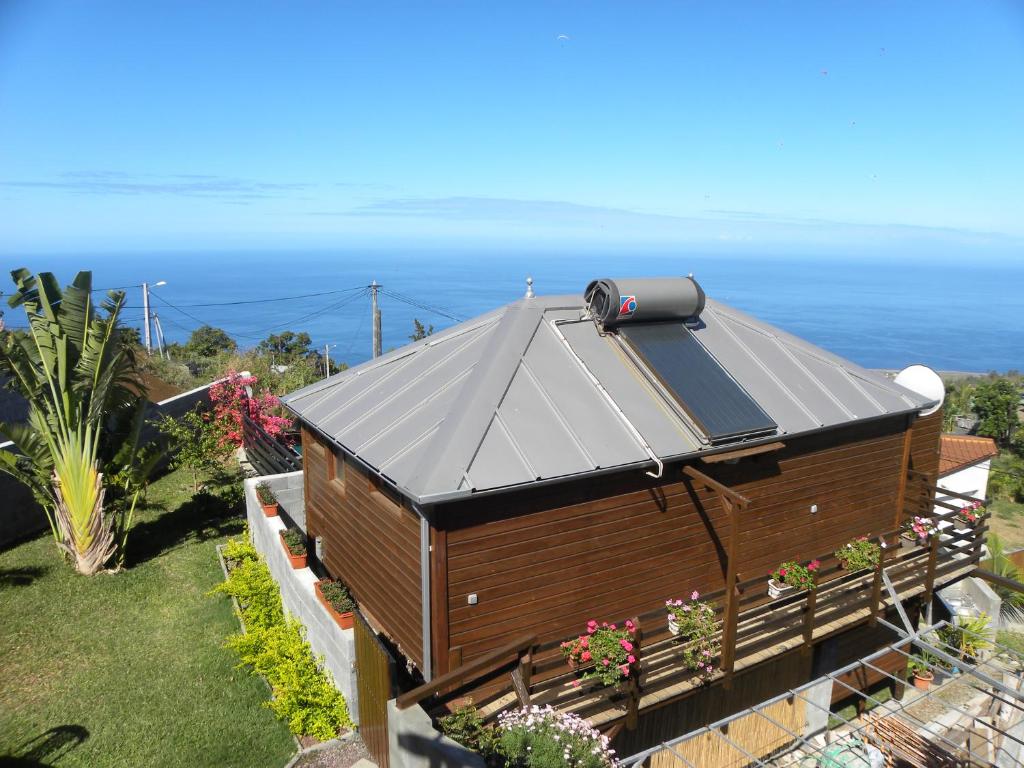 a large building with a roof with the ocean in the background at Le Chalet in Saint-Leu