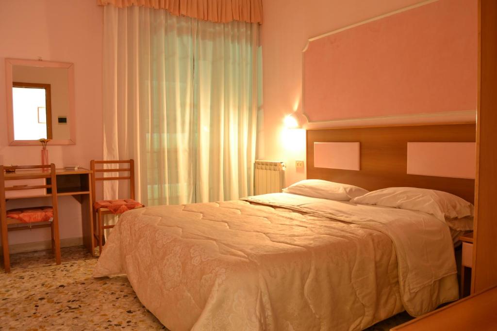 una camera con un grande letto e una finestra di Hotel Linda a Sorrento