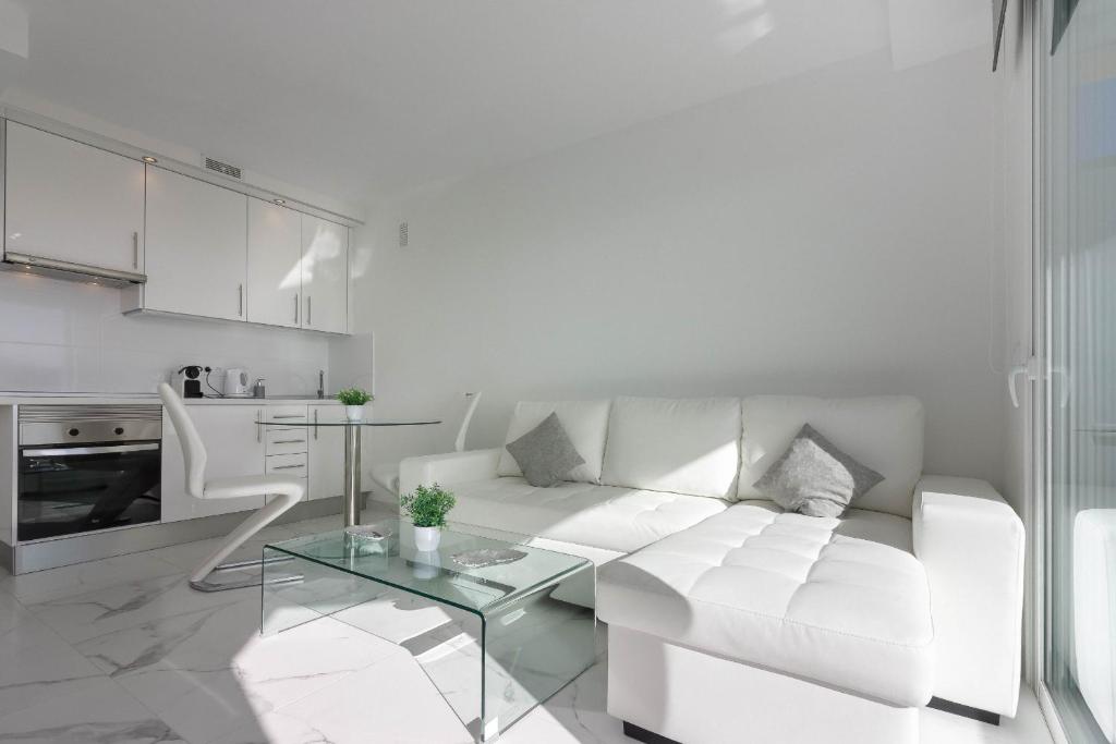 uma sala de estar branca com um sofá branco e uma mesa em Playa Honda 1A008 em Playa de las Americas