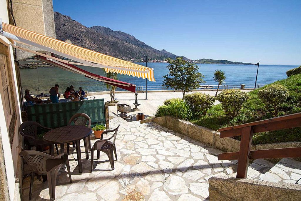 patio ze stołem i krzesłami przy plaży w obiekcie Paseo Mar 1 w mieście Arcos