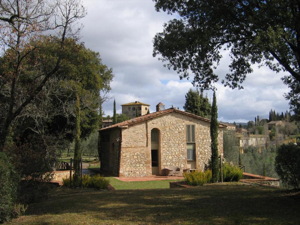 ein Steinhaus mit einem Turm darüber in der Unterkunft La Capanna di Castell'in Villa in Castelnuovo Berardenga