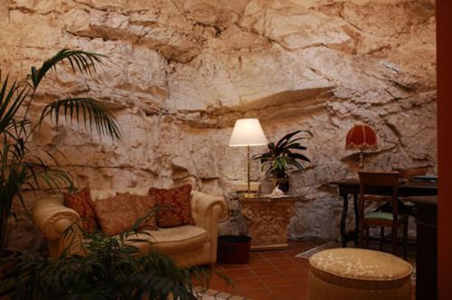 - un salon aux murs de pierre avec un canapé et une table dans l'établissement Hotel La Rocca, à Gubbio
