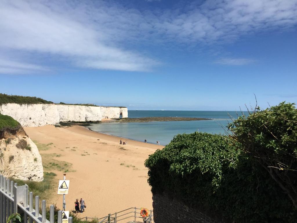 a beach with people walking on the sand at Seaview Cottage in Broadstairs