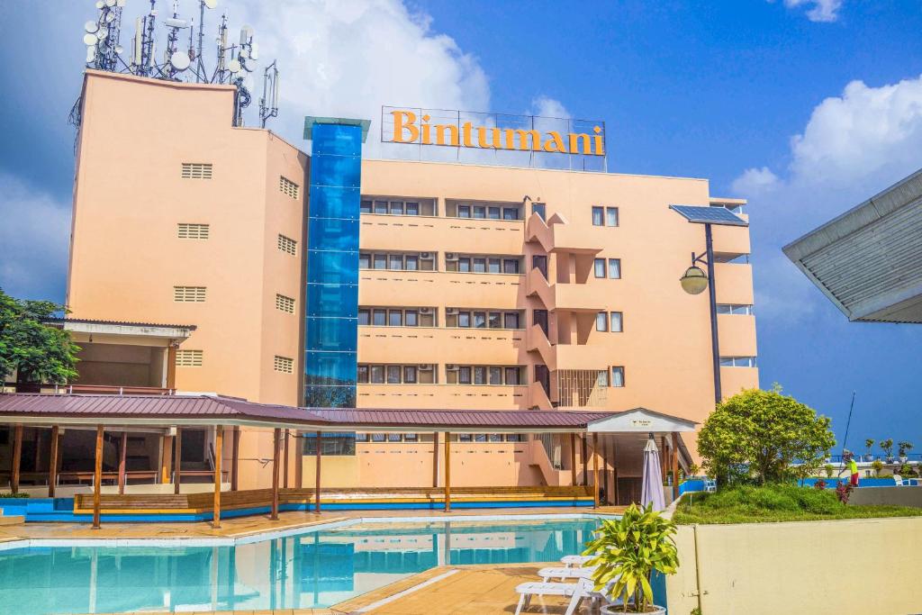 a hotel with a swimming pool in front of a building at Bintumani Hotel in Freetown