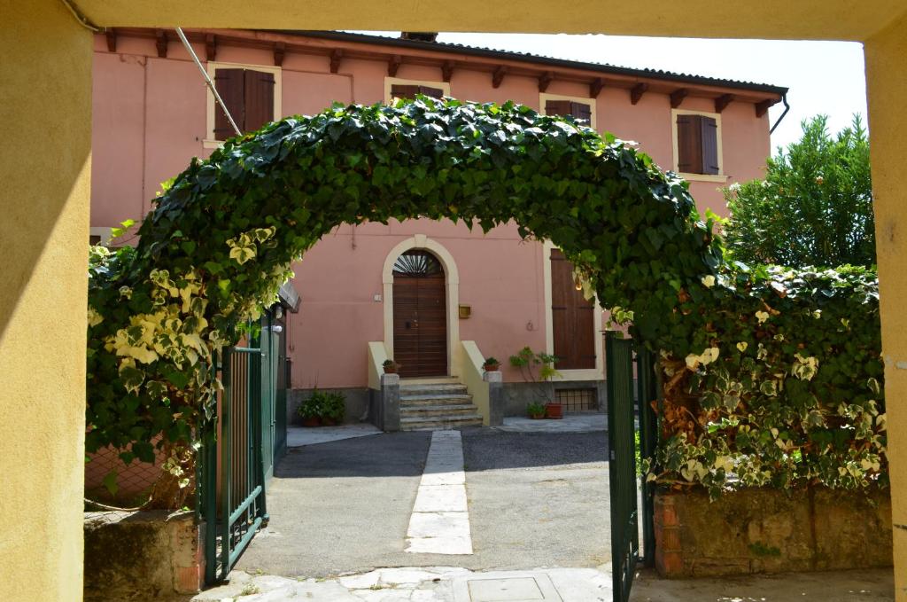 an entrance to a pink house with an arch of ivy at Veronauptoyou Apartments in Verona