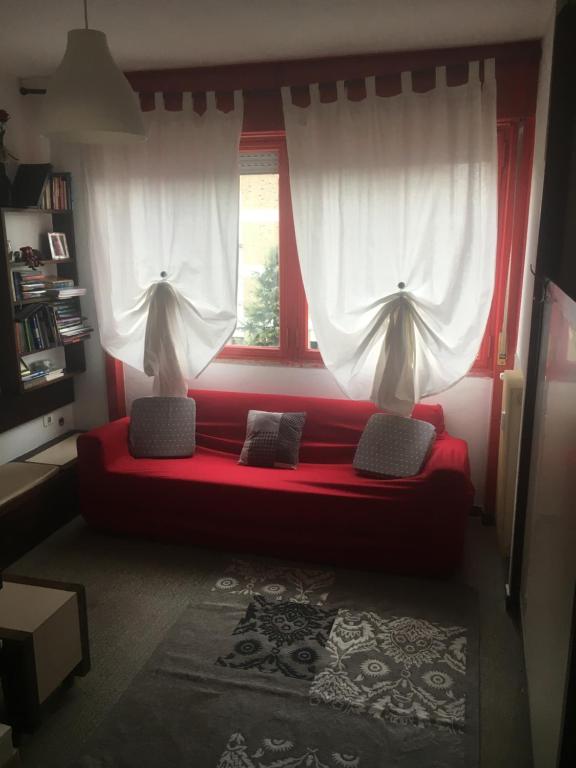 a red couch in a room with a window at Europa Red Apartment in Favaro Veneto