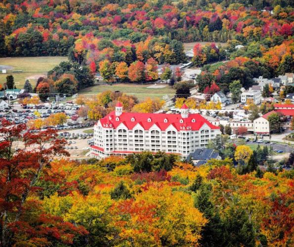 ein großes weißes Gebäude mit rotem Dach in einer Stadt in der Unterkunft RiverWalk Resort at Loon Mountain in Lincoln