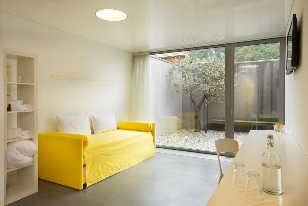a living room with a yellow couch and a table at Chromotel self check-in in Mezzovico