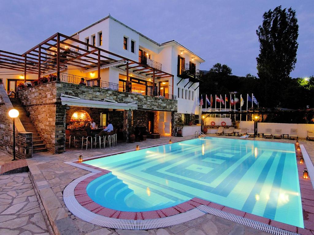 eine Villa mit einem Pool vor einem Haus in der Unterkunft Portaria Hotel in Portaria