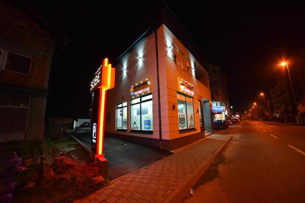 a building with a sign in front of it at night at Apartmani Milosevic in Bijeljina
