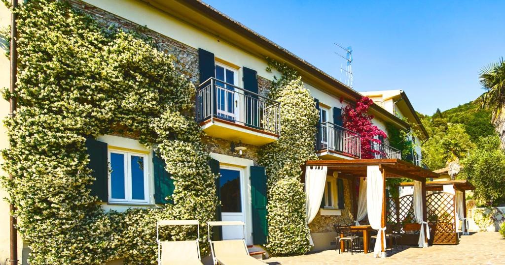 a building covered in ivy with two chairs in front of it at La Lucertola in Pugnano