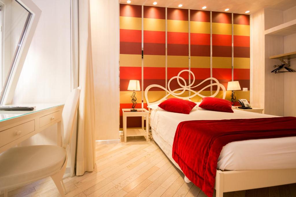 a hotel room with two beds and two lamps at Hotel Caravita in Rome