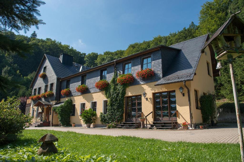 a house with flowers on the side of it at Flair-Waldhotel Mellestollen in Saalfeld