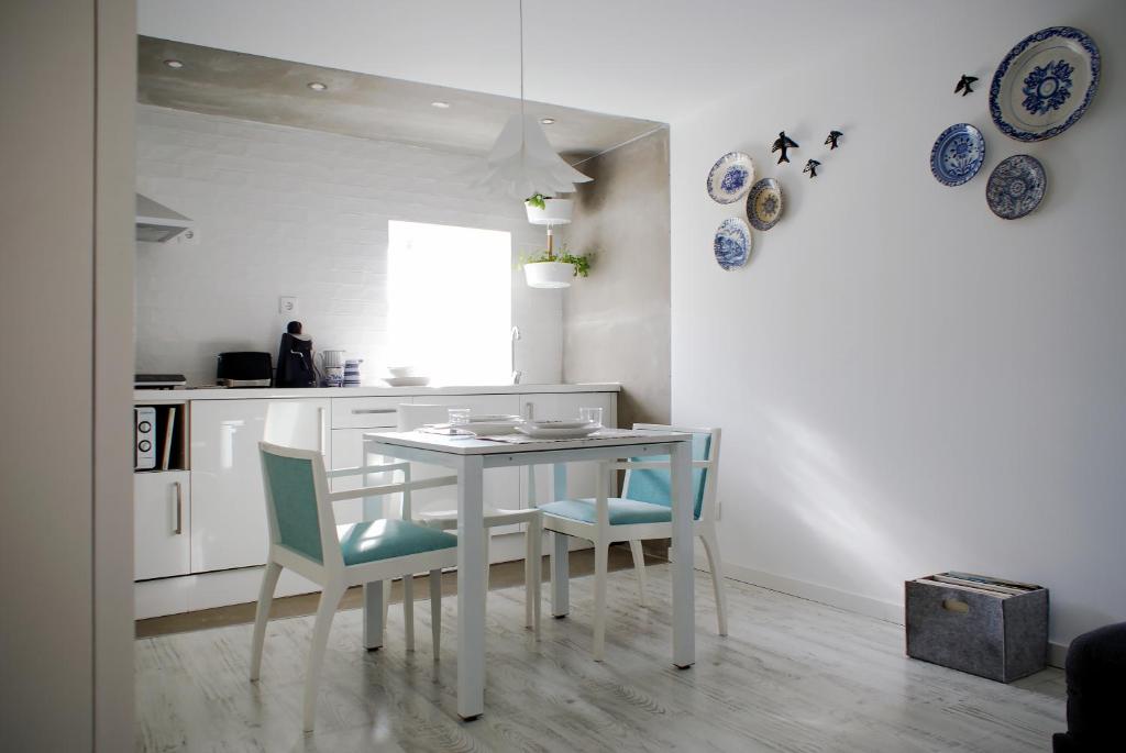 a white kitchen with a table and chairs at Casa do Meio in Coimbra