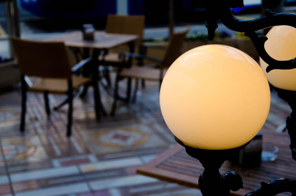 a lamp in a room with tables and chairs at Hotel Castilla Alicante in Alicante