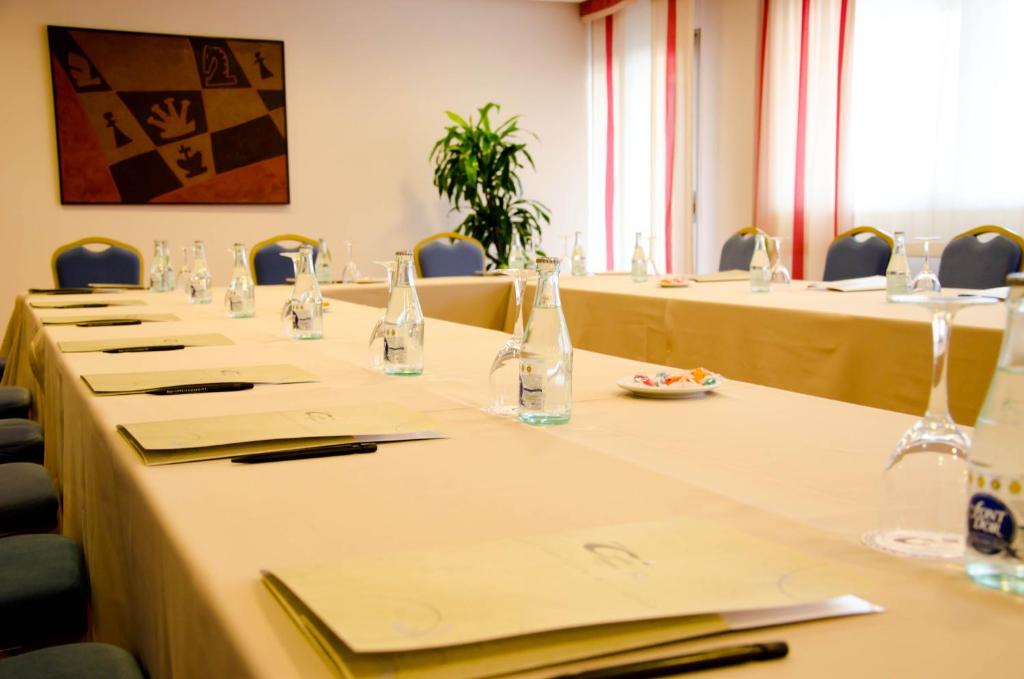 a row of long tables in a room with chairs at Hotel Castilla Alicante in Alicante