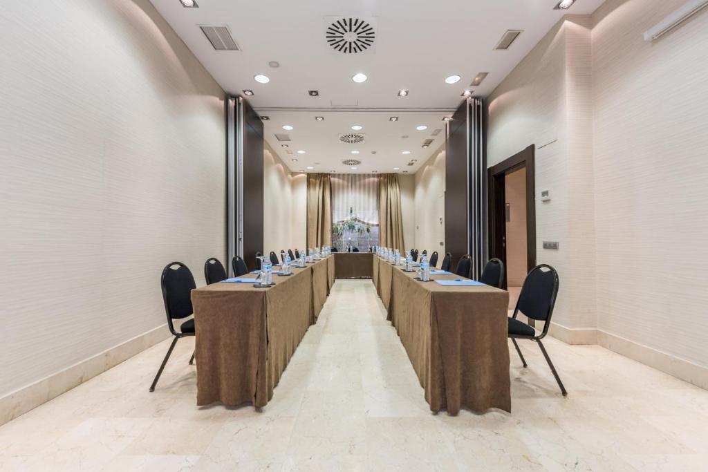 una sala de reuniones con una mesa larga con sillas. en Hotel Mercader, en Madrid