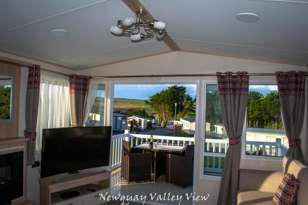 a living room with a view of a balcony at Newquay Valley View in Newquay