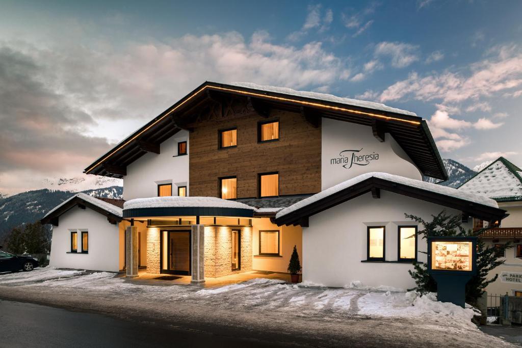 a large house with snow on the ground at Appartements Maria Theresia in Serfaus