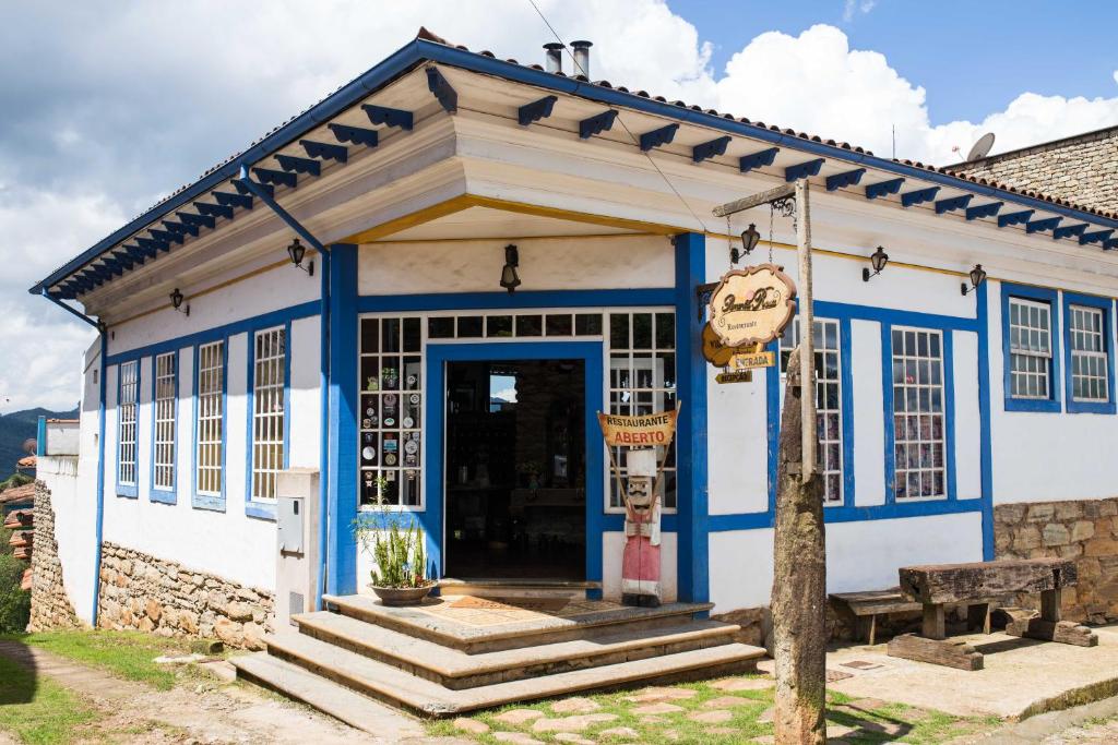 a blue and white building with a door at Pousada Vila Mineira in Lavras Novas