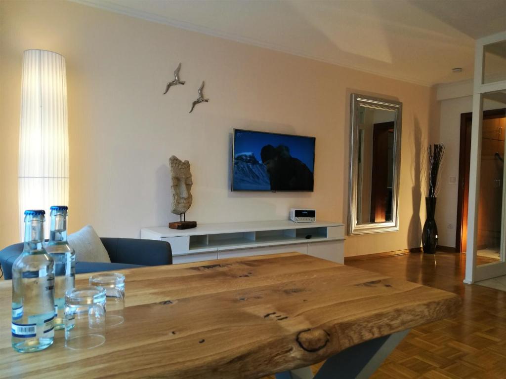 un soggiorno con tavolo in legno e TV di Bonsai-Apartment III An der Hufeland Therme a Bad Pyrmont