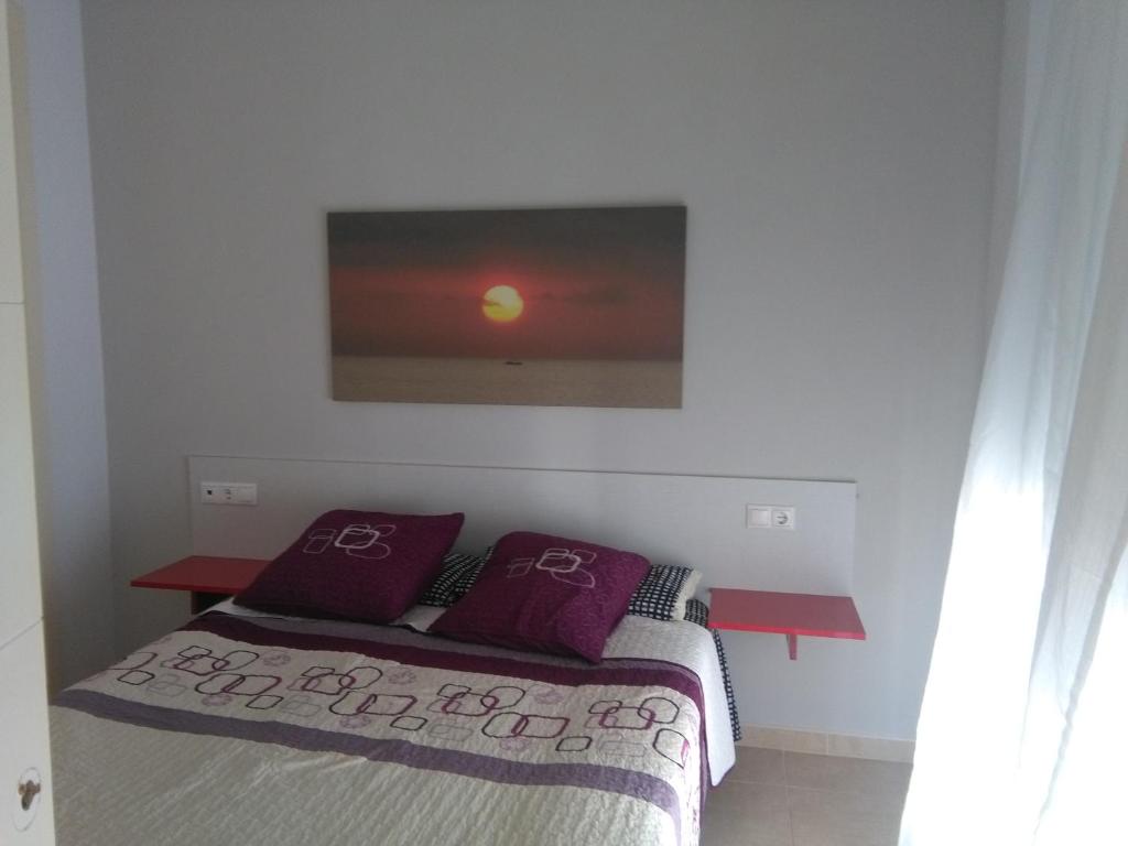 ベナルマデナにあるApartamento poleoのベッドルーム(紫色の枕とテレビ付)