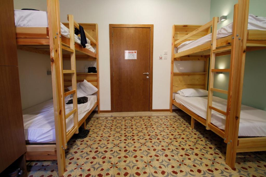 a room with three bunk beds and a door at Corner Hostel in Sliema