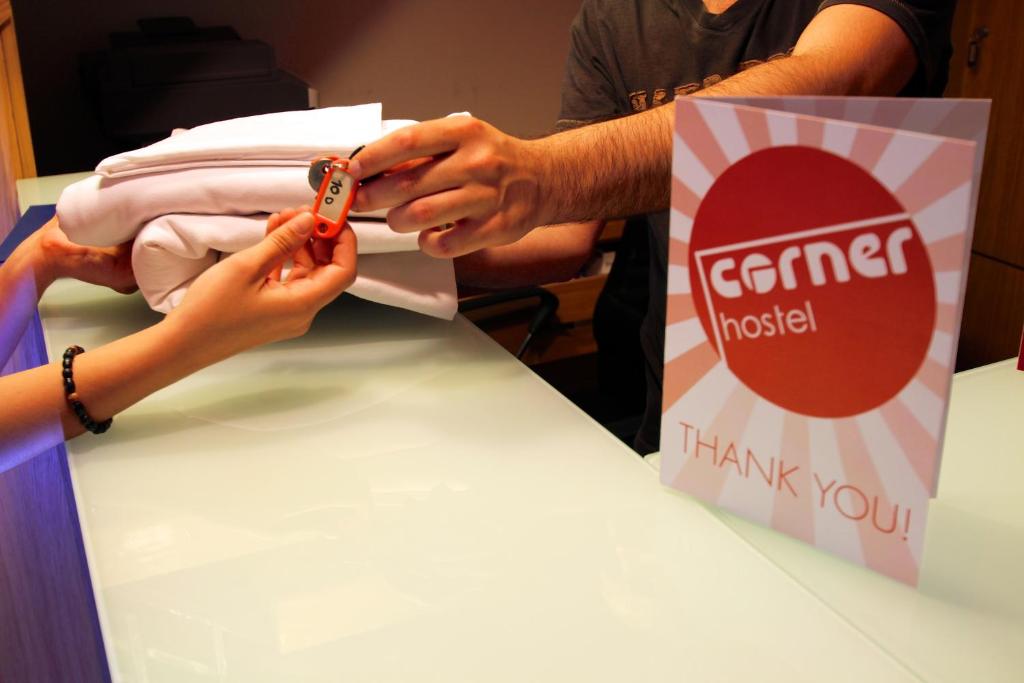 a person cutting a piece of paper on a table at Corner Hostel in Sliema
