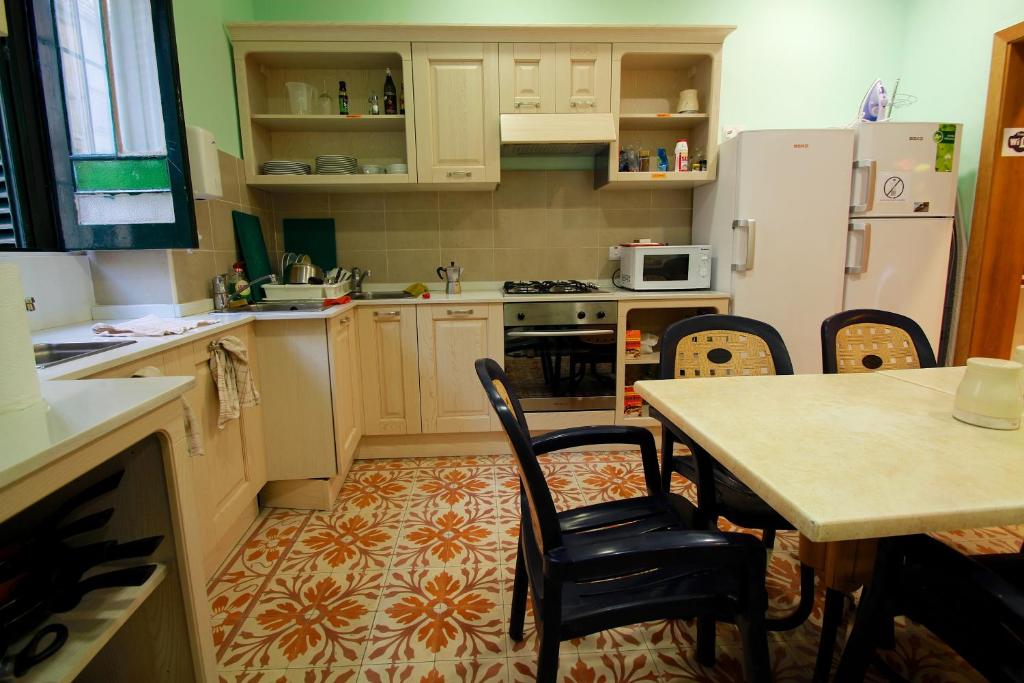a kitchen with a table and chairs and a refrigerator at Corner Hostel in Sliema
