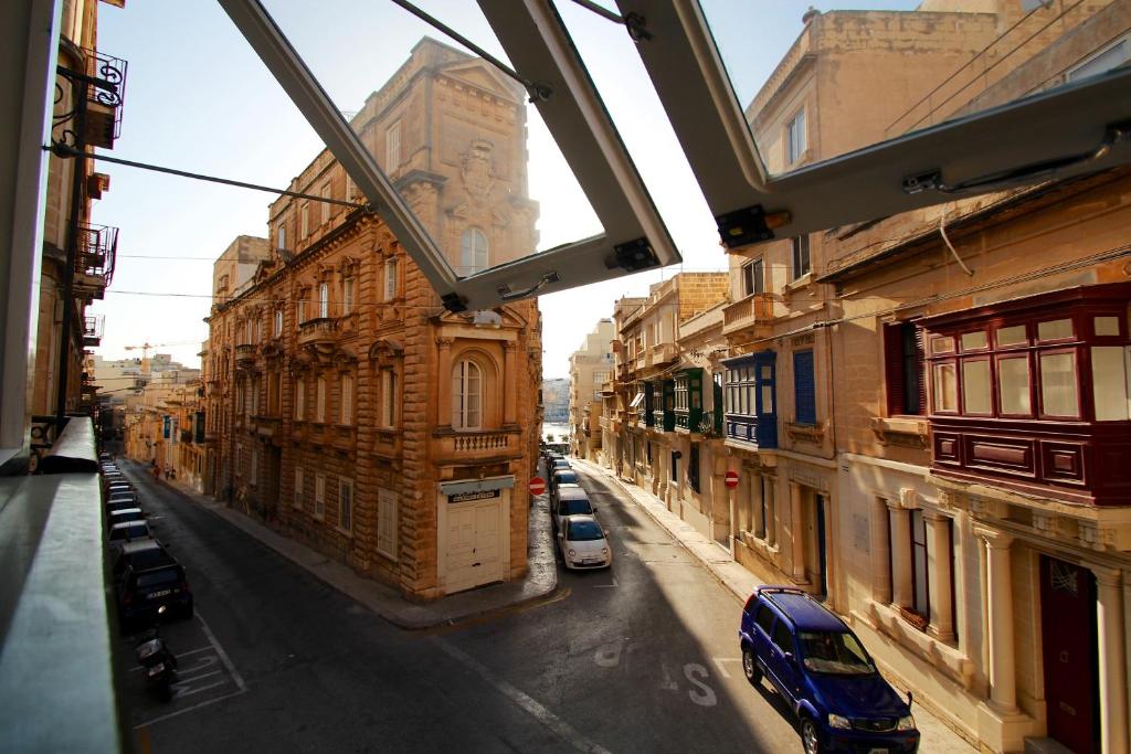 a view of a city street with buildings and cars at Corner Hostel in Sliema