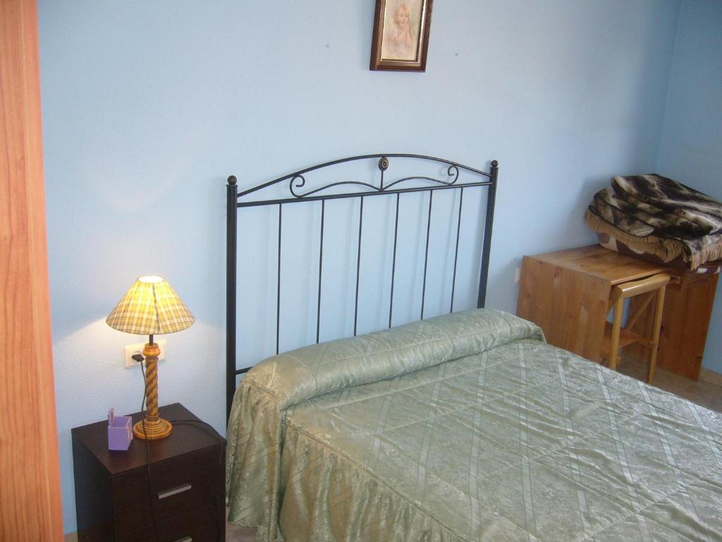 sypialnia z łóżkiem i lampką na stole w obiekcie Piso en calle Campo w mieście Tomelloso