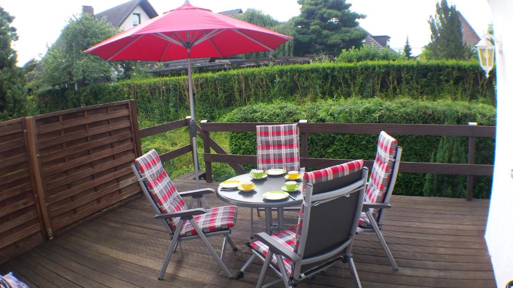 een tafel en stoelen met een parasol op een terras bij Ferienwohnung Katzenberger in Beverungen