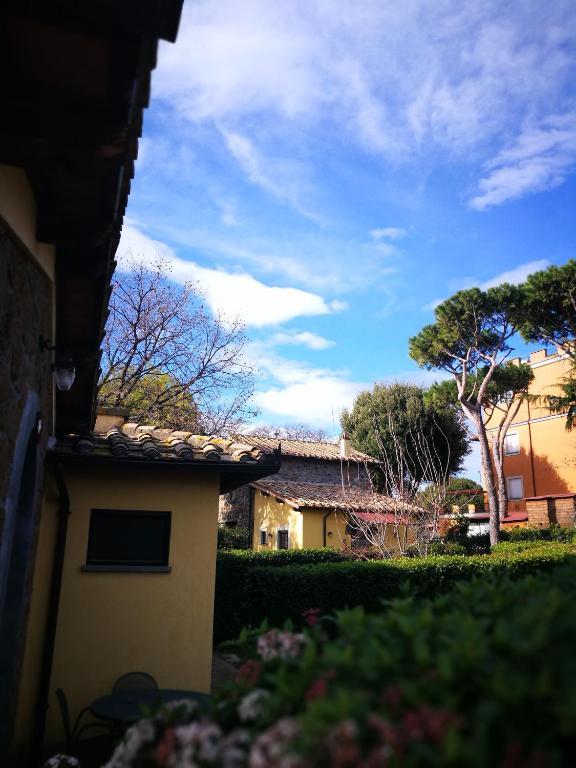 - une vue sur un bâtiment avec un arbre dans une cour dans l'établissement Podere La Branda, à Vetralla