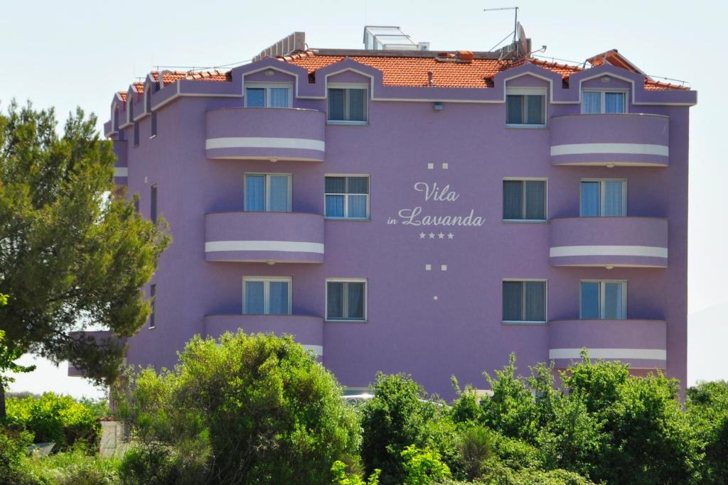 Un bâtiment violet avec un panneau sur lui dans l'établissement Vila in Lavanda, à Fažana