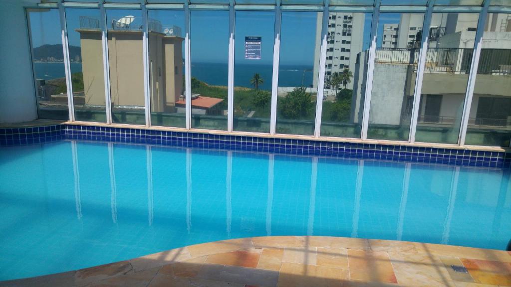 a swimming pool with a view of a building at Guarujá Flat in Guarujá