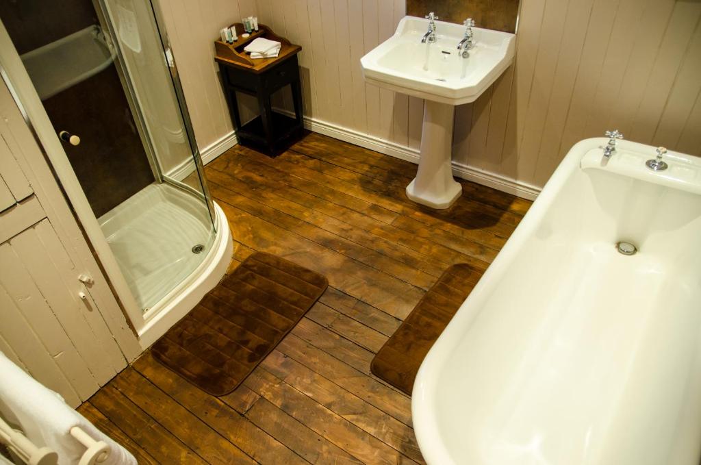 a bathroom with a shower and a tub and a sink at The Carrick in Portrush