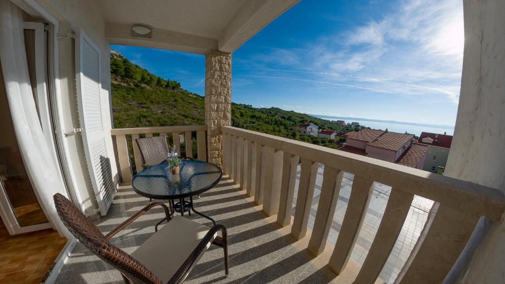 un tavolo e sedie su un balcone con vista sull'oceano di White Stone Villa 43 a Promajna