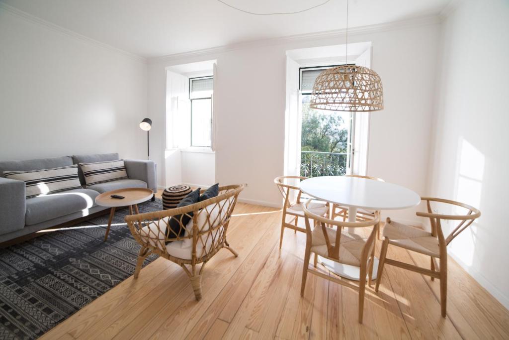 ein Wohnzimmer mit einem Sofa und einem Tisch in der Unterkunft FLH Madragoa Bright Place in Lissabon
