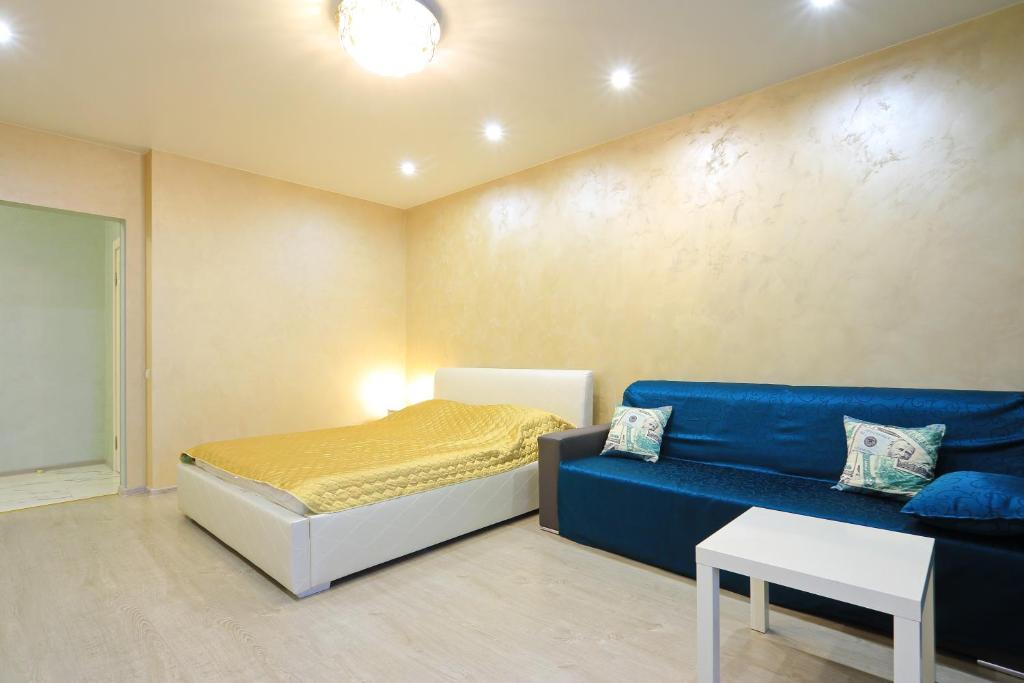カリーニングラードにあるVIP Apartment с кондиционером в престижном районеのベッドルーム(ベッド1台、青いソファ付)