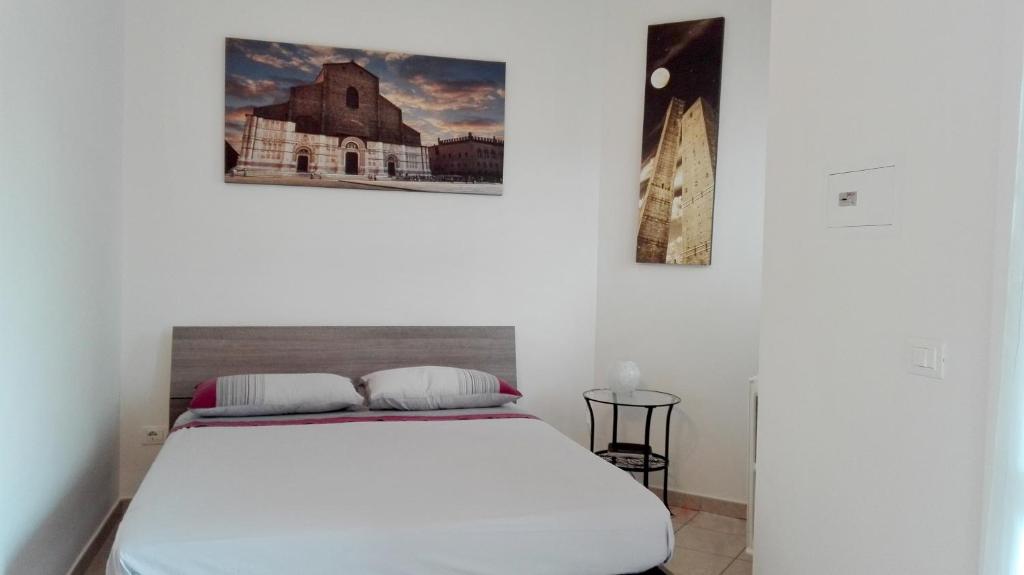 ボローニャにあるBeva Fiera Bolognaのベッドルーム1室(ベッド1台付)が備わります。壁に2枚の写真が飾られています。
