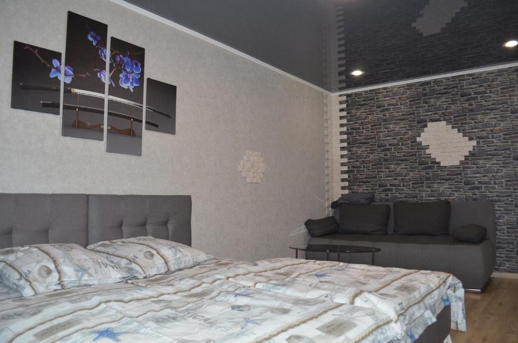 クルィヴィーイ・リーフにあるLux Apartment on Pushkinaのレンガの壁、ベッド付きのベッドルーム1室