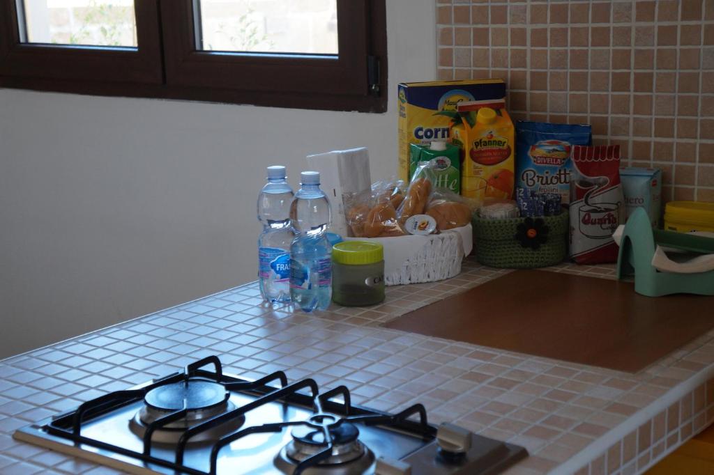 a kitchen counter with a stove and bottles of water at Antonella home in Brindisi