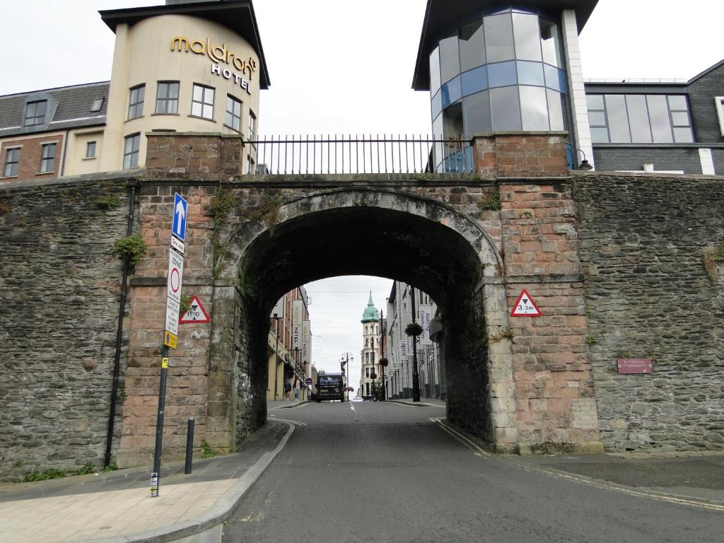 eine alte Steinbrücke mit einem Gebäude über einer Straße in der Unterkunft Tri ard house Derry city centre STILL OPEN in Derry Londonderry