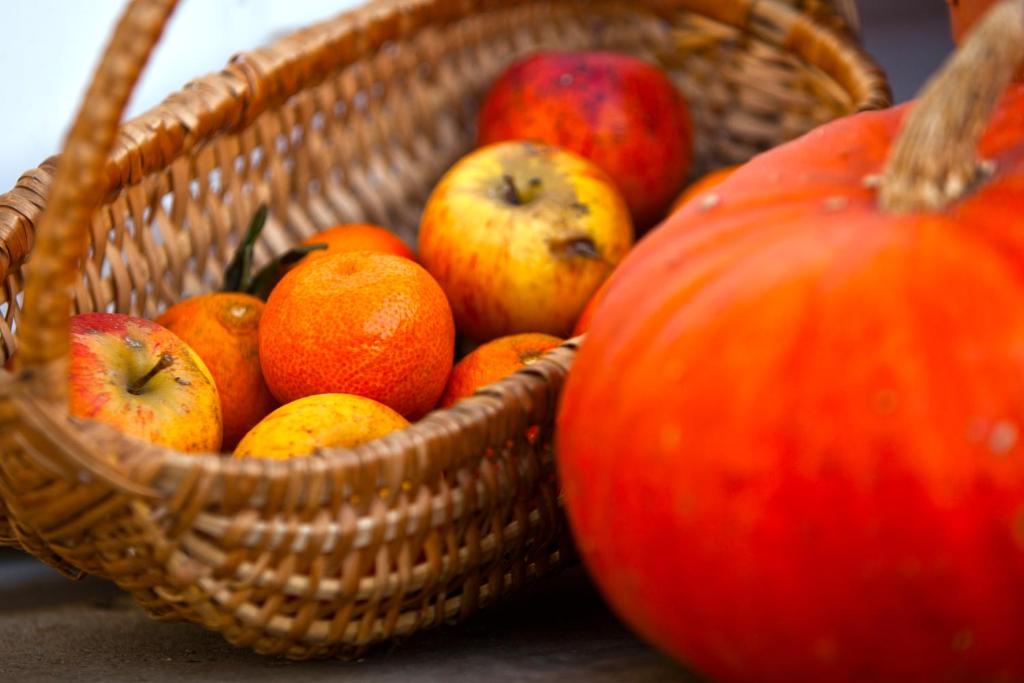 a basket of apples and oranges next to a pumpkin at Chambres d&#39;Hôtes La Fresnée in Mosles