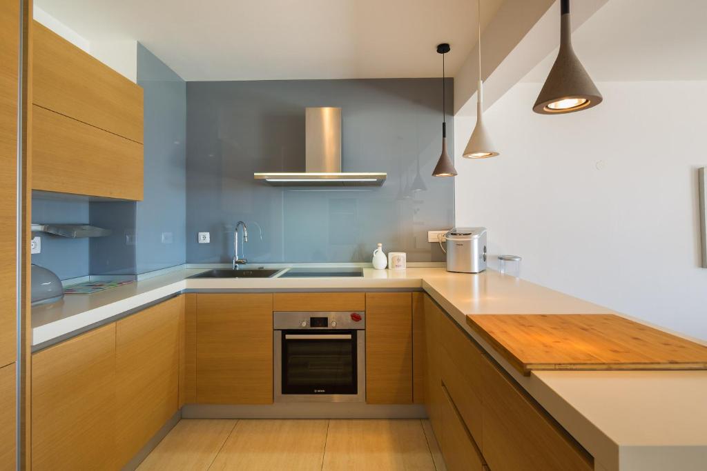 a kitchen with wooden cabinets and a sink at Apartments Blue Maris Žnjan in Split
